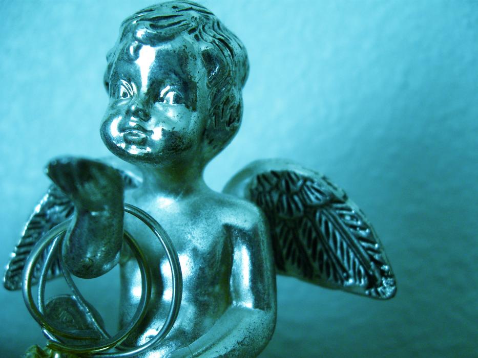 Iron statue of an angel on blue background