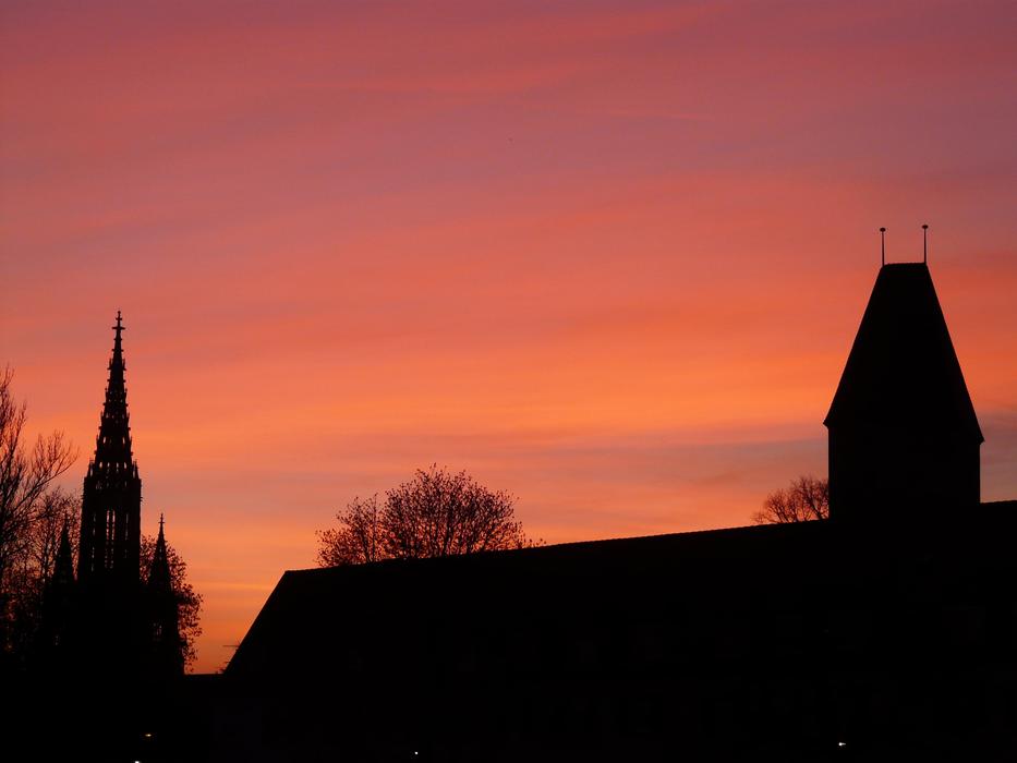a sunny sunset with a silhouette of a roof