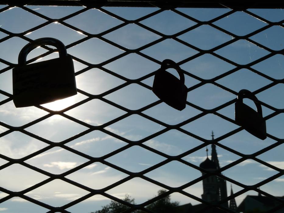 the silhouette of the locks on the fence