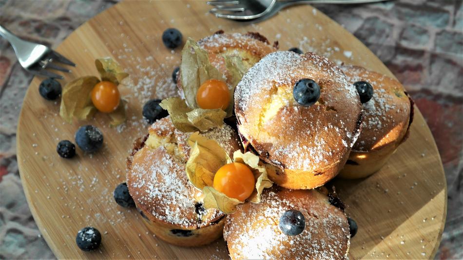 muffins with blueberries on a wooden cutting board