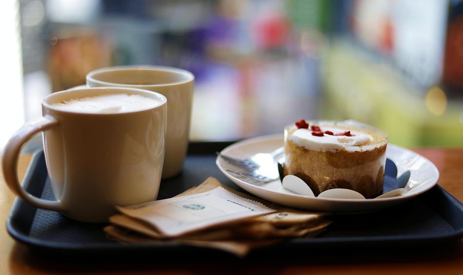 dessert and cups with coffee on a tray on a blurred background