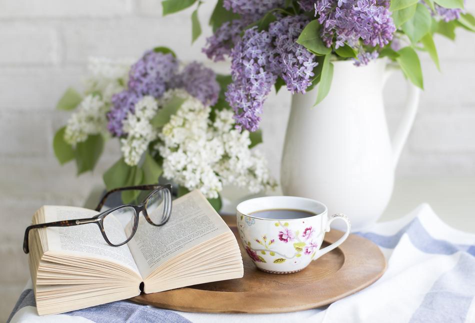 book and black coffee nearby the lilac