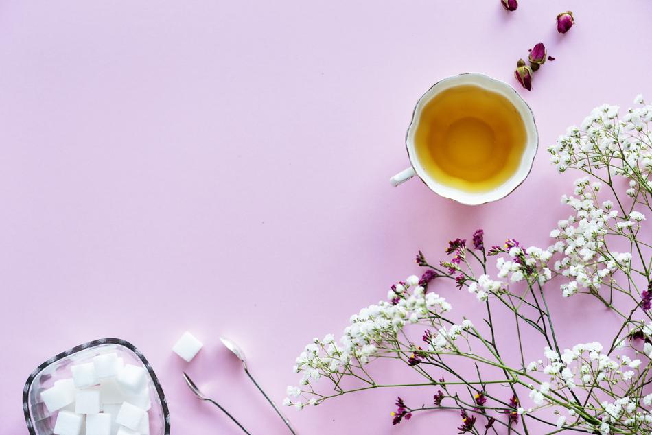 Flowers, sugar and drink in vintage cup, background with copy space