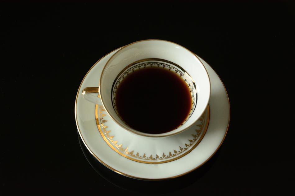 porcelain cup with drink on dark background