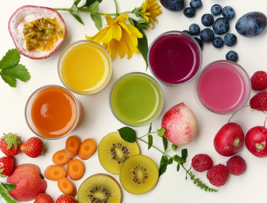 Top view of the beautiful and colorful smoothies in the glasses, among the colorful, different fruits and vegetables