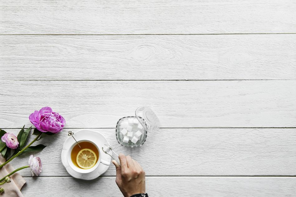 male hand at cup of Tea with lemon, background with copy space
