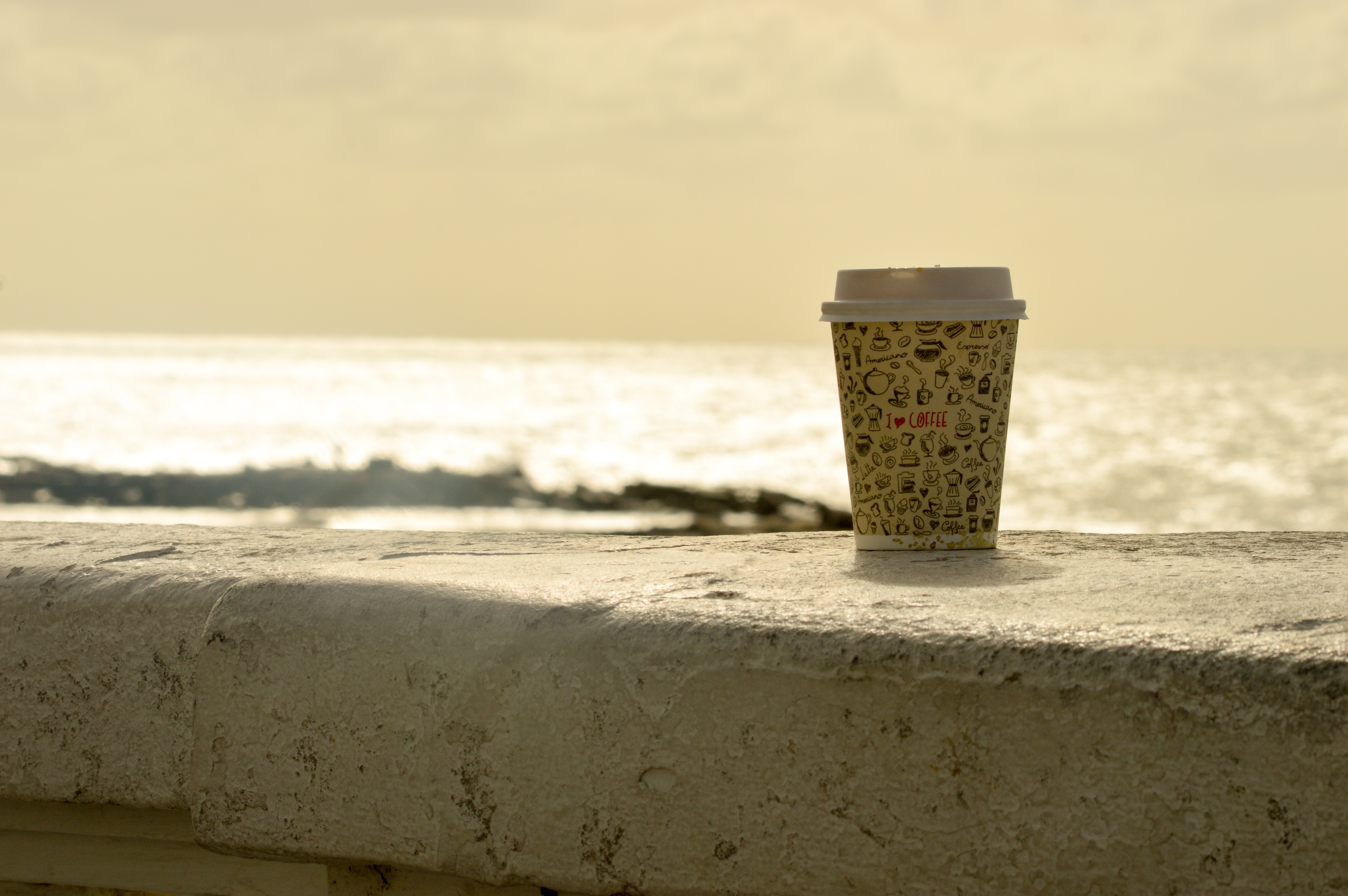 Стакан кофе на фоне моря