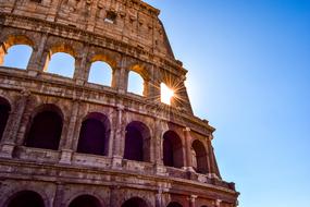 Beautiful Colosseum with arches, in sunlight, at blue sky on background, in Rome, Italy