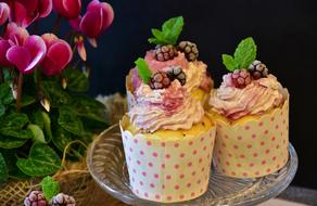 three muffins with cream and berries