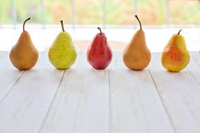 ripe multi-colored pears on a wooden surface