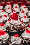 many cupcakes with cherries