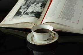coffee in a porcelain cup and an open book