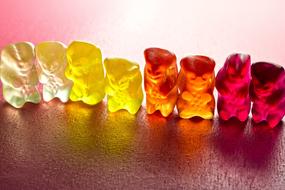 multi-colored chewing bears stand in a row