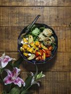 vegetable dish on a plate and purple lilies