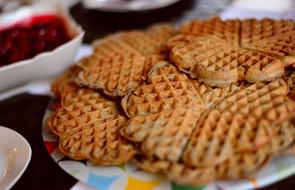 Beautiful, baked waffles, on the colorful plate, near the purple jam