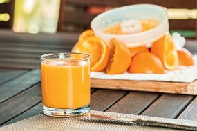 crumpled oranges and a glass of orange juice