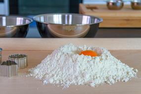 egg at top of Flour pile on table in kitchen