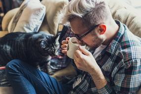 man on the sofa drinking coffee