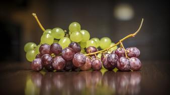 red and green grapes in mirror reflection