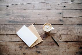 coffee, note sheets and a pen on a wooden table