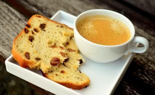 Beautiful and colorful slices of the cake, on the white plate, with the cup of coffee