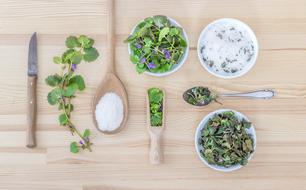 greens, seasonings and kitchen utensils on the table