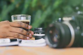 Coffee Cup in male dark skin hand at camera