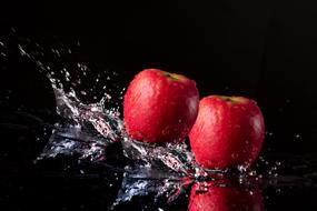 spray of water and two red apples