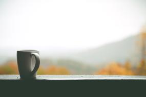 coffee mug on blurred landscape background
