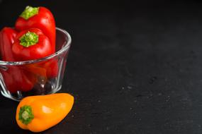 red and yellow Peppers at black Background