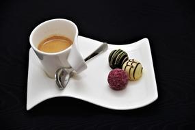 cup of espresso and candy on a white plate