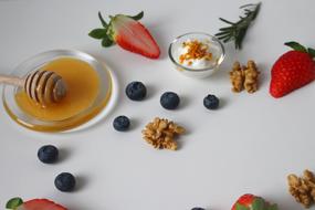 honey, sour cream, nuts and berries on the table