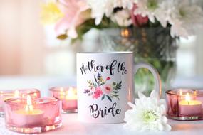 Beautiful and colorful flowers, with candles and mug for the mother of the bride