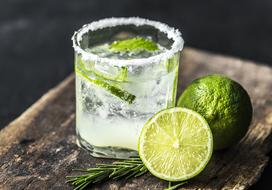 lemonade with ice and lime close-up on blurred background