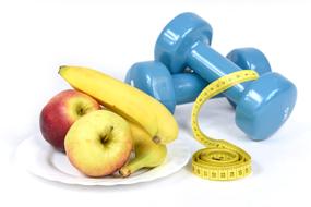 dumbbells, measuring tape and fruit on a plate