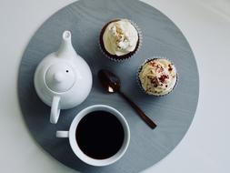 teapot, cup of tea and cakes on a tray