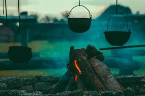 Cooking pots, above the campfire with wood, on the beautiful landscape
