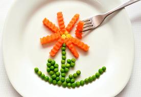 peas and carrots in the shape of a flower on a plate