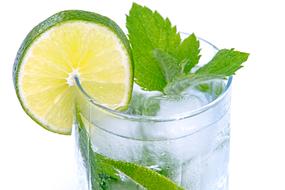 Shiny cold drink with the ice, lime and green mint, in the glass