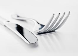 Knife And Fork on a white shiny surface close-up