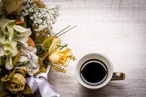 beautiful fresh bouquet and cup of coffee on the table