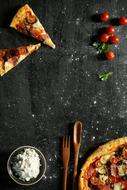 Pizza and Cooking utilities on black table