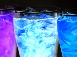 multicolored drinks with ice on black background