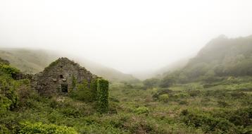 abandoned building on a hill during fog