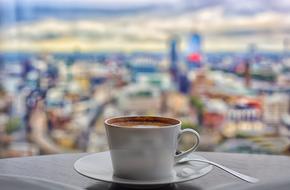 coffee cup on table on blurred city background