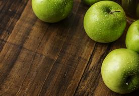 green apples on a wooden surface