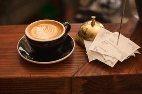 Coffee in dark cap on bar