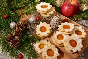 Christmas cookies, fir branches and red apple on the table