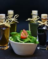 Olive and Walnut Oils and vinegar around bowl with vegetarian salad