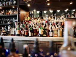 a large assortment of alcohol on the shelves of the bar